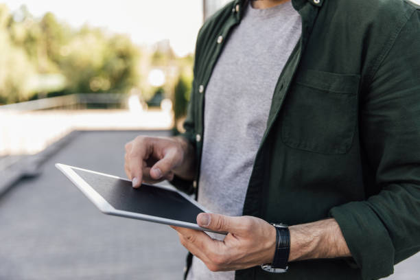 istock cropped view of young man using digital tablet in city 807280446