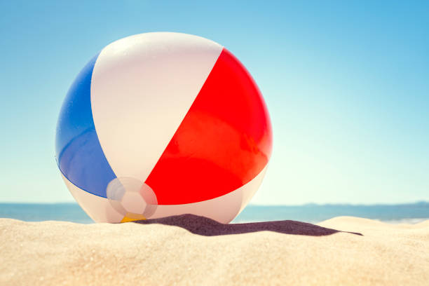 Beach ball on the sand Beach ball resting in sand dune concept for childhood summer vacations, family holiday and healthy lifestyle beach ball beach summer ball stock pictures, royalty-free photos & images