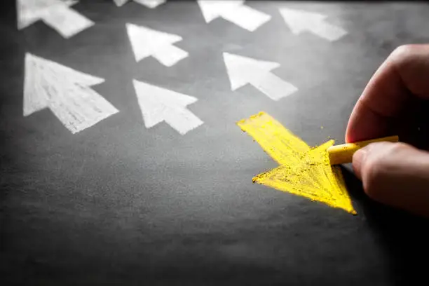 Photo of Individuality going a different direction chalk arrow on blackboard