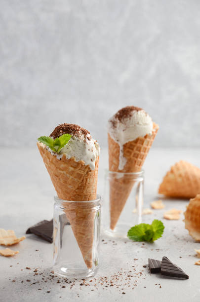 istock Vanilla ice cream in waffle cone with chocolate crumb on grey concrete background 807298444