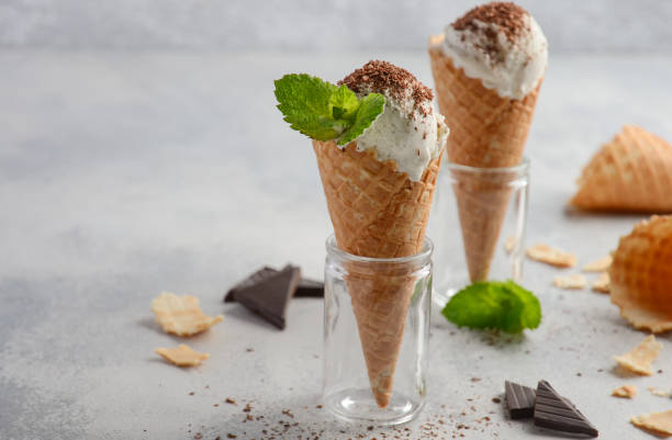 istock Vanilla ice cream in waffle cone with chocolate crumb on grey concrete background 807298466