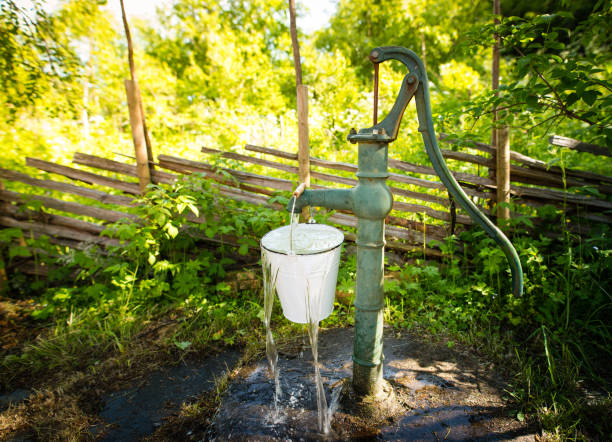 old hand water pump outside in the garden - well fountain water pipe pipe imagens e fotografias de stock