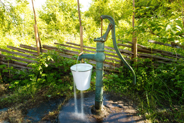 old hand water pump outside in the garden - well fountain water pipe pipe imagens e fotografias de stock