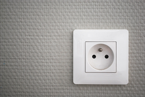 White french electrical outlet/plug on a wall.