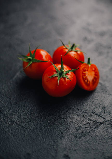黒い背景に新鮮なトマト - トマト ストックフォトと画像