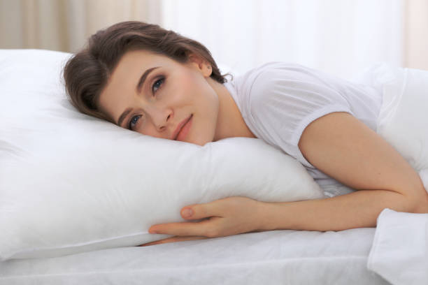 istock Beautiful young woman sleeping while lying in her bed and relaxing comfortably. It is easy to wake up for work or the day off. Concept of pleasant and rest reinstatement for active life 807319676