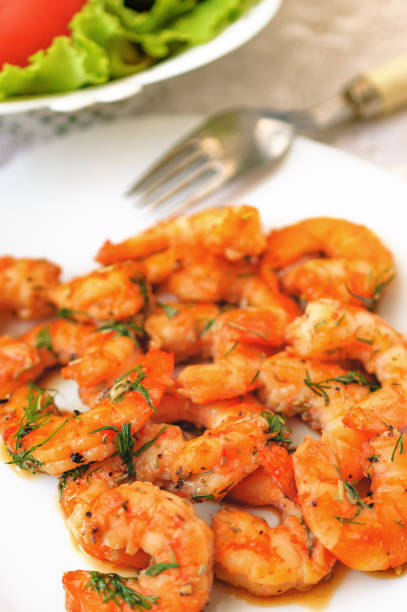 istock Fried tiger prawns with herbs on a white plate 807324320