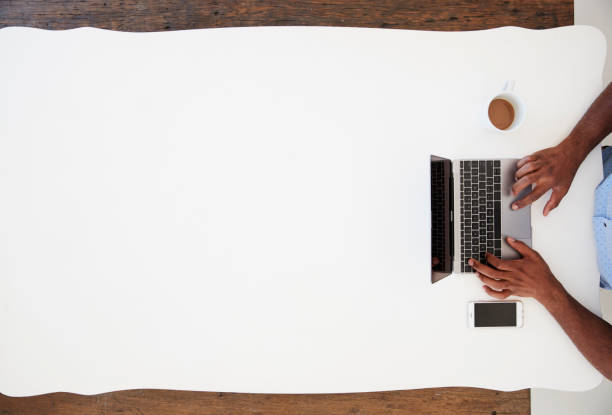 Black businessman using laptop at a desk, overhead shot