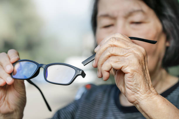 пожилая азиатская женщина ремонт разбитых очков - distraught 70s asian ethnicity women стоковые фото и изображения