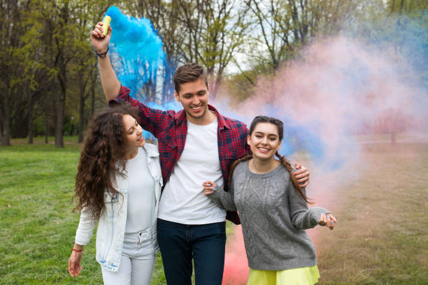 istock Young friends firing colourful smoke torches 807376162