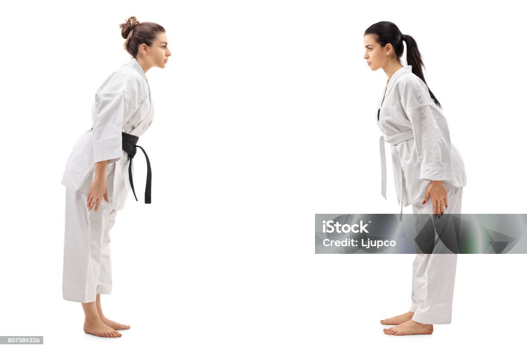 Dos mujeres jóvenes vestidas con kimonos cediendo uno al otro - Foto de stock de Judo libre de derechos