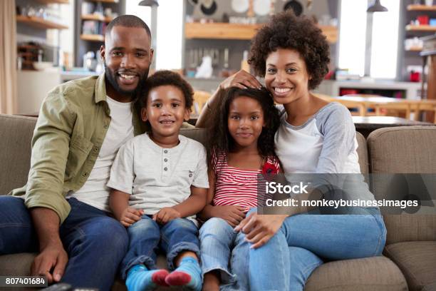 Porträt Der Glückliche Familie Auf Dem Sofa Sitzen In Offene Lounge Stockfoto und mehr Bilder von Familie