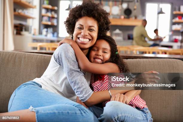 Portrait Of Mother And Daughter Sitting On Sofa Laughing Stock Photo - Download Image Now
