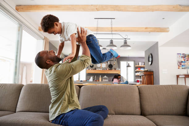 istock Father And Son Playing On Sofa In Lounge Together 807401918