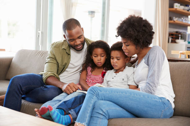 istock Family Sitting On Sofa In Lounge Reading Book Together 807401976