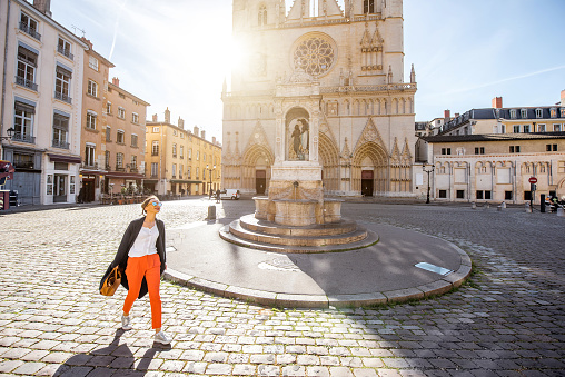 Morning view on the saint John cathedral with woman walking on the square in the old town of Lyon city