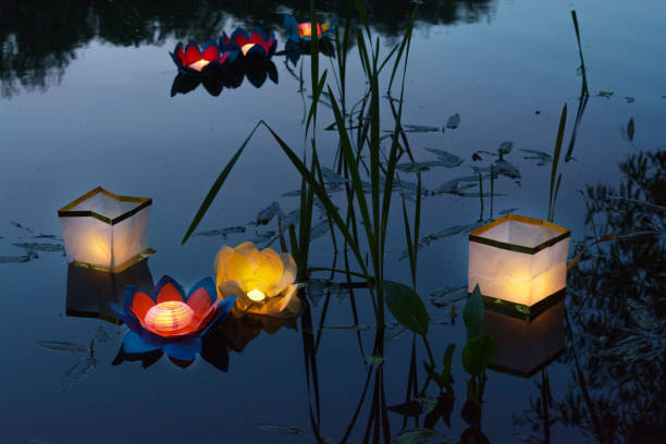istock Water burning yellow lanterns on the lake amid tall grass 807402196