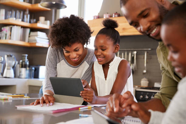 istock Parents Helping Children With Homework In Kitchen 807402216