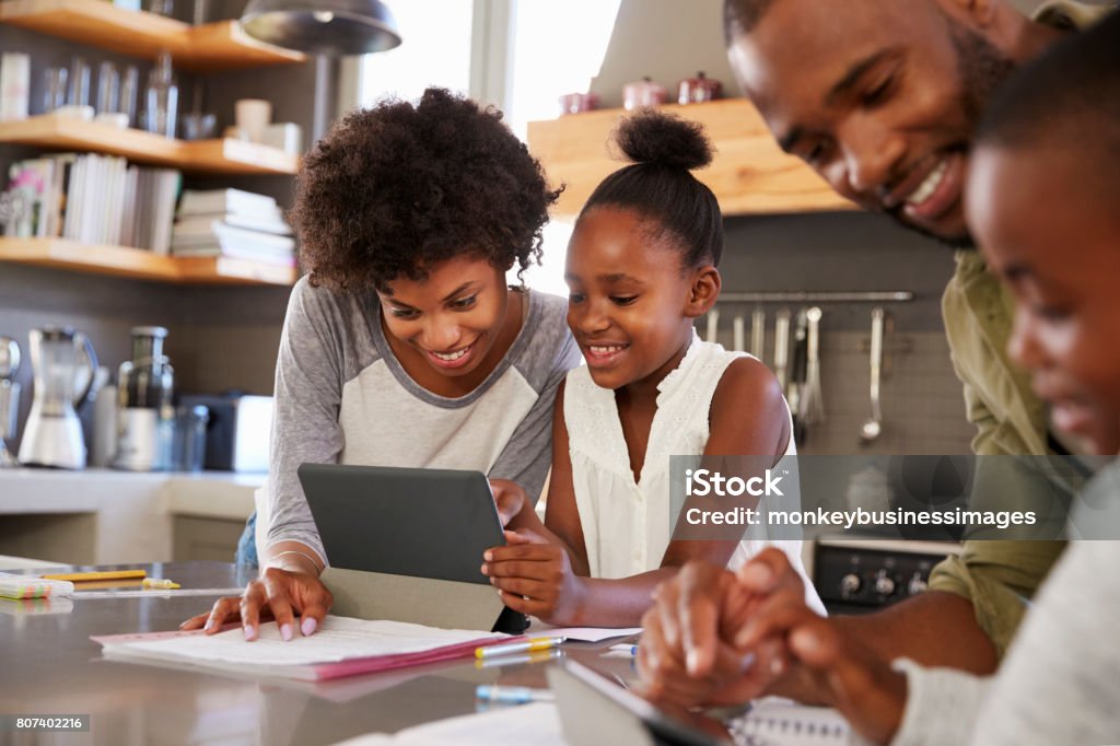 Parents Helping Children With Homework In Kitchen Homework Stock Photo