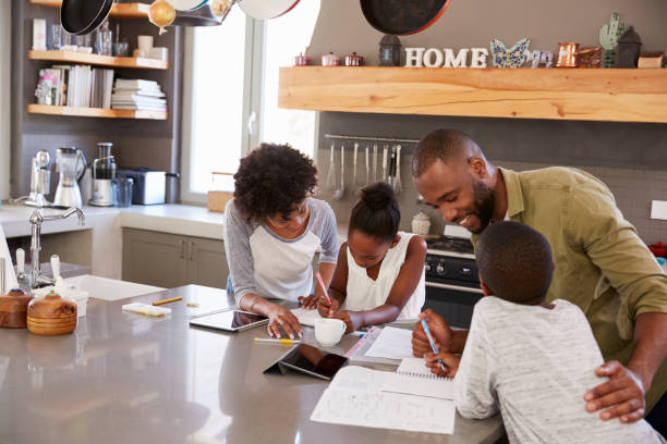 istock Parents Helping Children With Homework In Kitchen 807402220