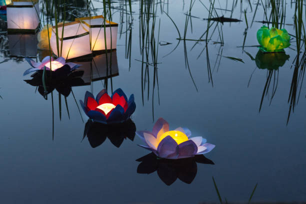 istock Water burning yellow lanterns on the lake amid tall grass 807402276