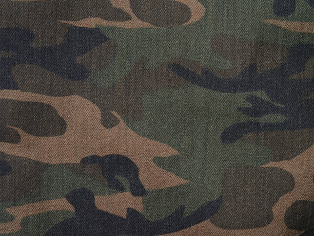 istock Camouflage brown and green denim military textile background horizontal 807405562
