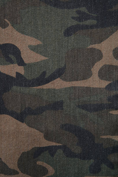 istock Camouflage brown and green denim military textile background vertical 807405570