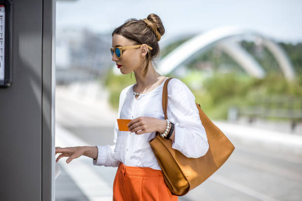 istock Woman buying a ticket or using ATM outdoors 807406022