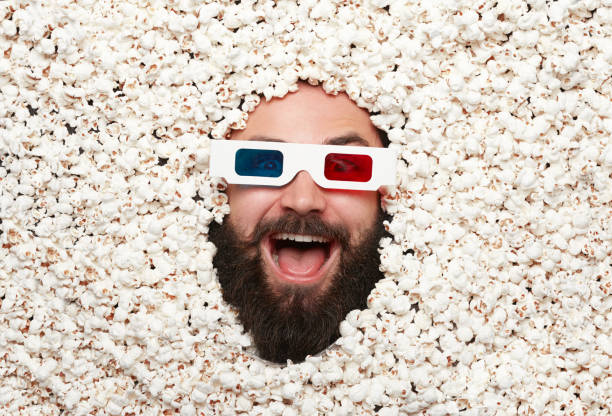 istock Delightful man in 3-D glasses in popcorn 807406162