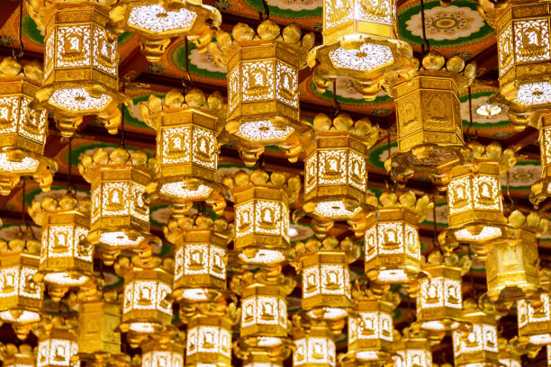 Traditional oriental Chinese golden ceiling lanterns in a Buddhist temple.