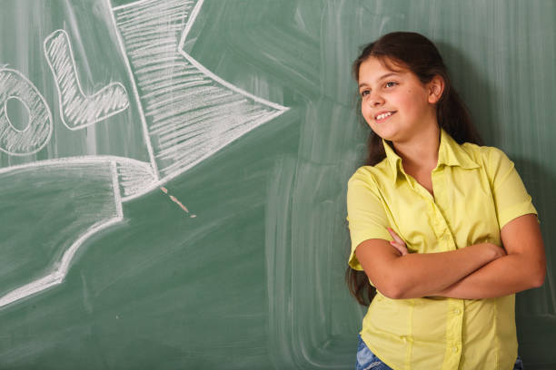 istock Young girl against blackboard 807408810