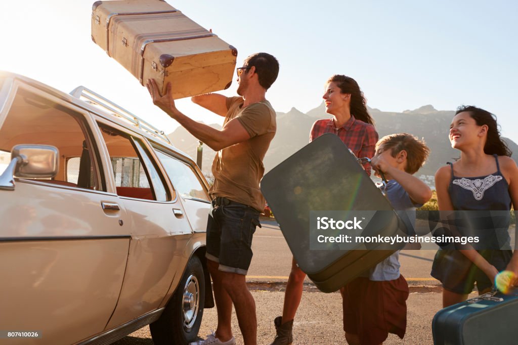 Familia cargando equipaje en coche techo listo para el viaje - Foto de stock de Coche libre de derechos