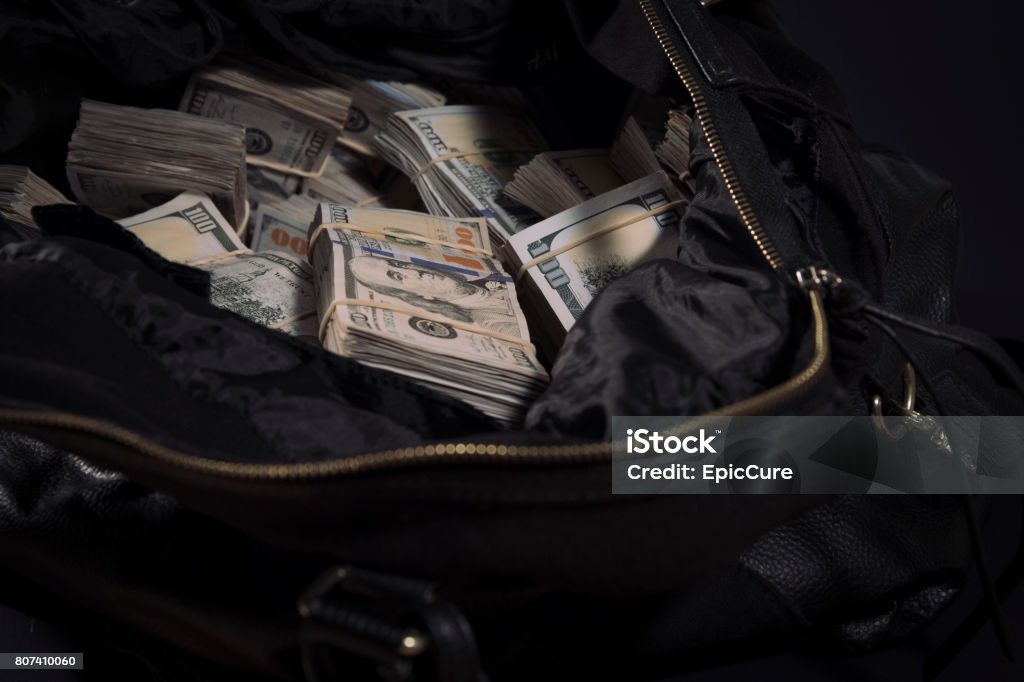 Duffel bag bag with cash Leather bag with lots of 100 dollar bills Currency Stock Photo
