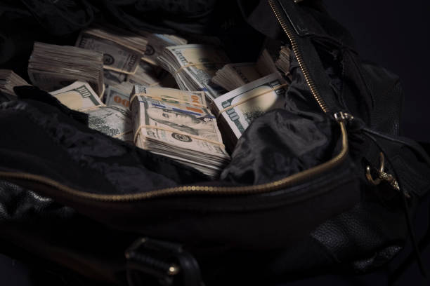 Duffel bag bag with cash Leather bag with lots of 100 dollar bills bribing stock pictures, royalty-free photos & images