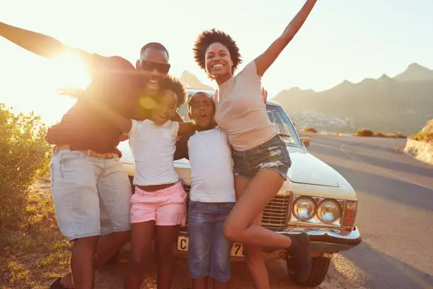 Photo of Portrait Of Family Standing Next To Classic Car