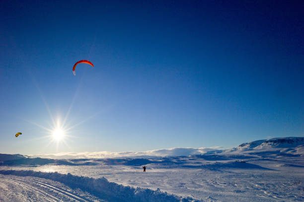 Snowkites in the sky at sundown