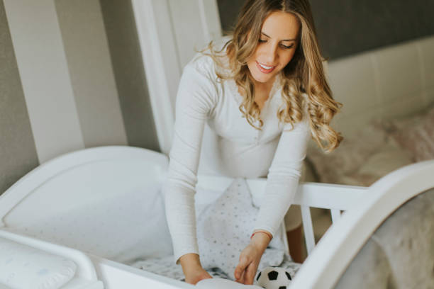 istock Pregnant woman setting up baby crib 807415534