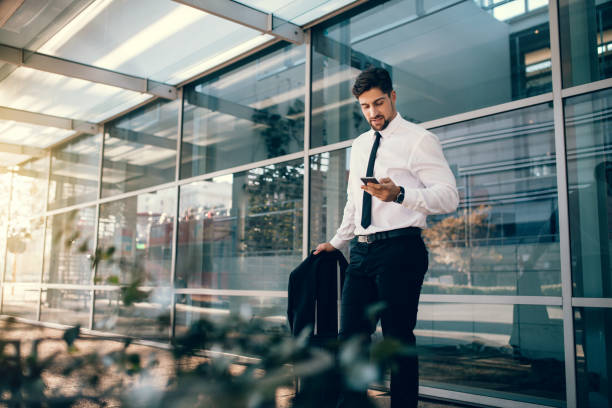 istock Businessman standing with luggage and using smart phone 807416090