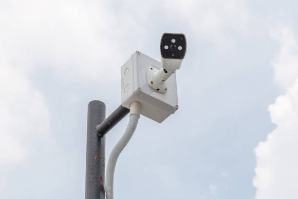istock Security camera, CCTV is installed for monitoring on building with blurred blue sky in background 807419398
