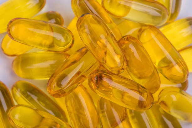 istock Yellow soft gelatin capsules common use in pharmaceutical manufacturing industry, extract natural essential oil supplements. 807419760