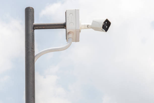istock Security camera, CCTV is installed for monitoring on building with blurred blue sky in background 807425228