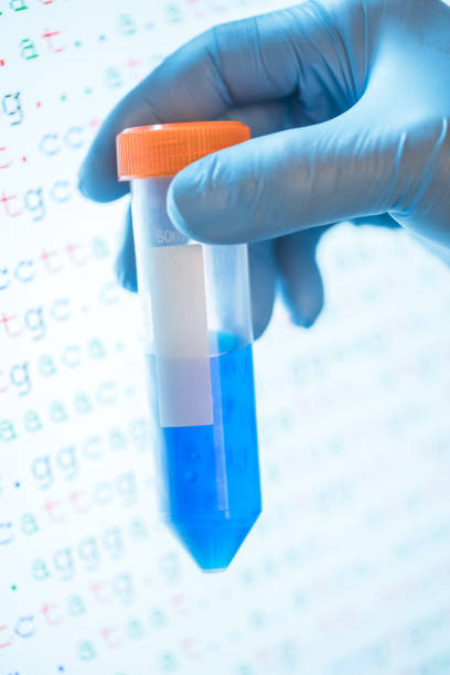 istock 50ml centrifuge tube with blue solution with DNA sequence in the background 807429510