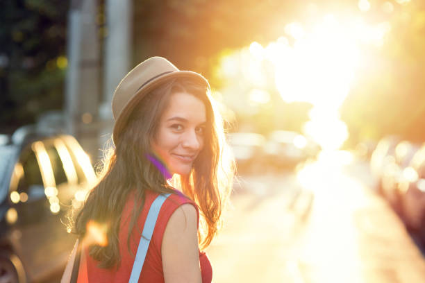 Girl walking on the street and looking at camera over her shoulder
