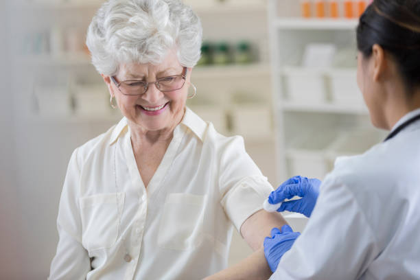 senior pharmacy customer smiles nervously before flu shot - prescription doctor rx pharmacist imagens e fotografias de stock