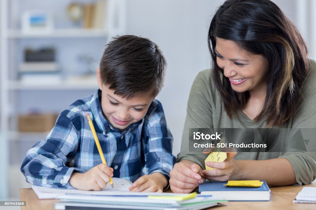 Stolze Mama ermutigt Sohn, wie er Hausaufgaben macht - Lizenzfrei Kind Stock-Foto