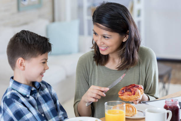 istock Happy mom and son eat breakfast together 807443380