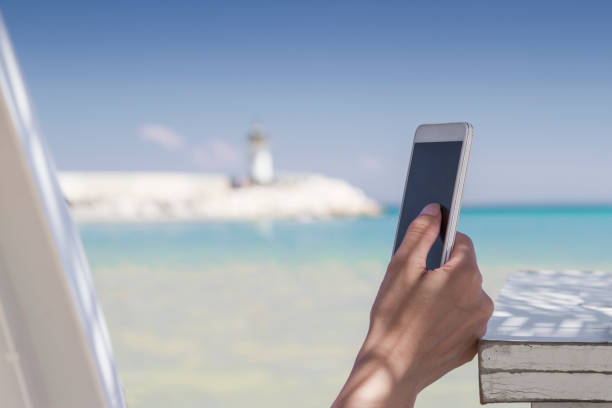 istock Woman using her smartphone at the beach 807443518