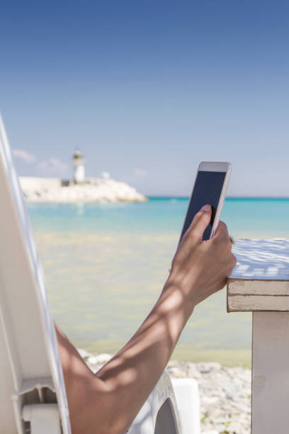 istock Woman using her smartphone at the beach 807443528
