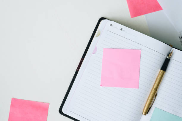 istock Top view open notebook, pen and post it on white desk background with copy space 807471696