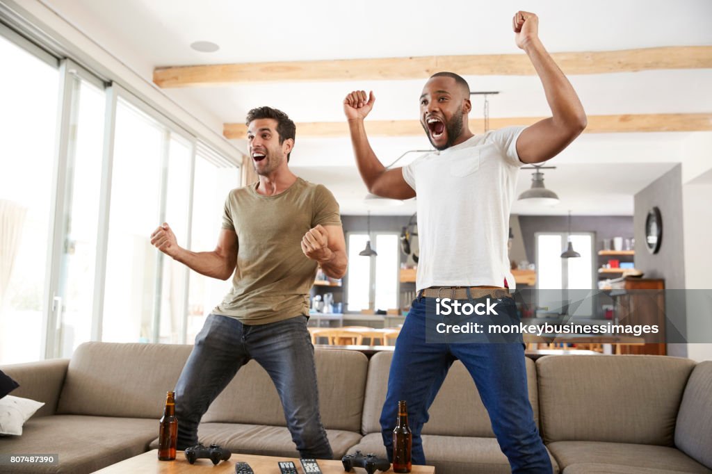 Zwei aufgeregte männliche Freunden zu feiern, Sport im Fernsehen ansehen - Lizenzfrei Fan Stock-Foto